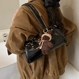 Bolso baguette negro brillante al hombro con lindo amuleto de oso de punto marrón