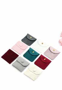 Collection of colorful velvet jewelry envelope pouches featuring secure snap button closures
