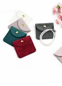 Assorted microfiber jewelry pouches with gold snap buttons and pearl necklace detail