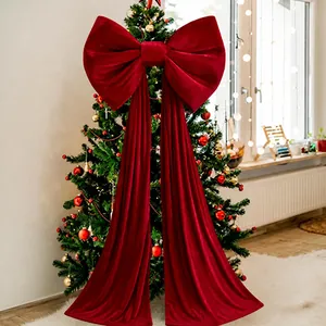 Nahaufnahme einer großen roten Samtschleife an einem geschmückten Weihnachtsbaum