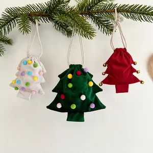 Nahaufnahme von drei festlichen Kordelzugbeuteln in Weihnachtsbaumform am Zweig