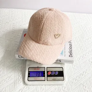 Detail showing the 137g weight of the alpaca velvet baseball cap with rhinestone heart
