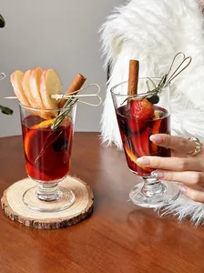 Elegant glass for mulled wine featuring festive fruit garnish in a cozy winter setting