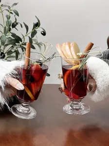 Detail shot of elegant mulled wine glasses with festive garnishes and sliced fruit.