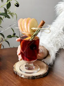 Winter mulled wine glass with apple and cinnamon decoration in cozy setting