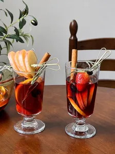 Macro view of an elegant glass for hot mulled wine with festive Christmas fruit garnishes