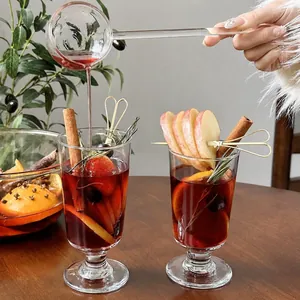 Elegant glass mulled wine cup for Christmas cocktails with cinnamon and fresh fruit slices