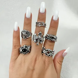 Gros plan d'un ensemble de bagues gothiques vintage avec motifs crâne et étoile sur main
