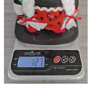 Creative ladybug plush gnome doll showing a weight of 127 grams on a digital scale