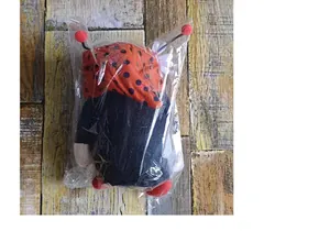 Close-up view of a packaged ladybug plush doll with red polka dot hat and cute antennae