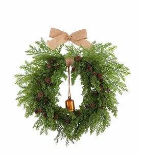 Close-up detail of artificial Christmas wreath featuring burlap bow and bronze bell