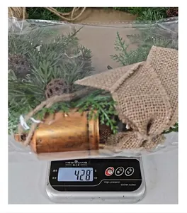 Detailed weight measurement view of Christmas wreath featuring pine cones and burlap bow