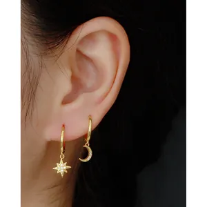 Close-up of gold S925 sterling silver star and moon hoop earrings with cubic zirconia