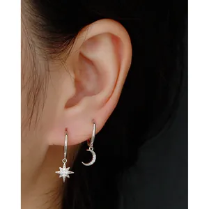 Close-up of S925 sterling silver star and moon hoop earrings with pavé zircons