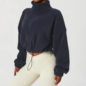 Close-up of navy blue fleece jacket with high neck zipper and adjustable drawstring hem