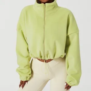 Detail of light green cropped fleece jacket with high collar and drawstring hem