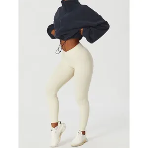 Model wearing navy blue stand collar fleece drawstring jacket and cream workout leggings