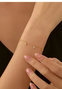 Dettaglio bracciale croce stella luna oro indossato al polso per eleganza