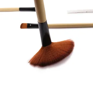 Primer plano de una brocha abanico profesional con cerdas suaves y mango de madera