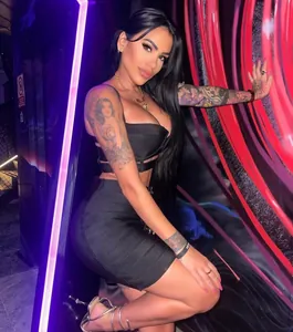 Close-up detail of a sexy black two-piece outfit featuring a crop top and buckle mini skirt
