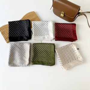 Vista dettagliata di sei eleganti foulard quadrati a pois in finta seta in vari colori
