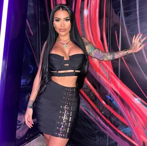 Detail view of a black bandage two-piece set with a buckled mini skirt and crop top.
