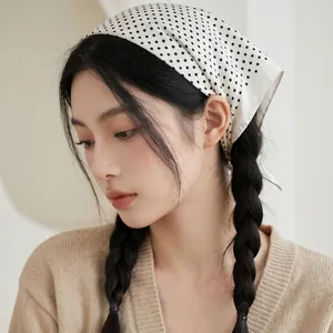 Elegante foulard di seta francese a pois, indossato come un fazzoletto da capo.