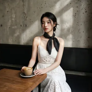Donna elegante che indossa un foulard di seta a pois neri in stile francese in un caffè.