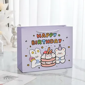 Detailaufnahme der lila Cartoon-Geschenktüte mit Happy Birthday und süßem Hasen-Druck