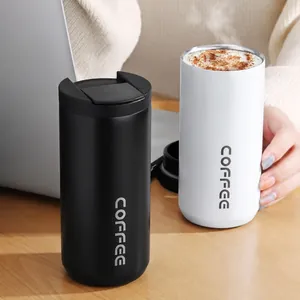 Detailweergave van geïsoleerde roestvrijstalen koffiebekers op een bureau