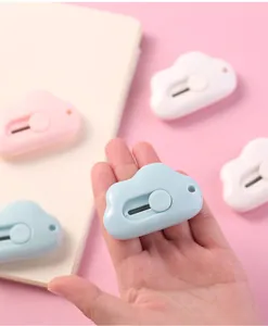 Portable mini cloud-shaped utility knife held in hand showing compact size for DIY tasks