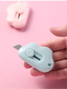 Detailed view of hand holding a mini cloud-shaped utility knife for box opening