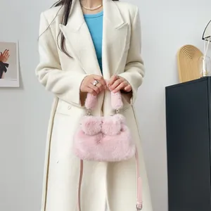 Elegante rosa Kunstpelz-Handtasche mit Schleifen-Pompons, präsentiert an einem Modell