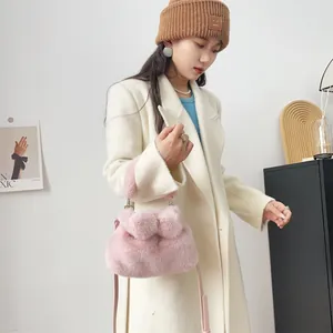 Mode-Modell im weißen Mantel mit einer rosa Kunstpelz-Schleifen-Handtasche im Detail