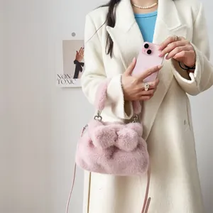 Detailansicht der rosa Handtasche aus Nerzimimitat mit einer süßen Dekorschleife.