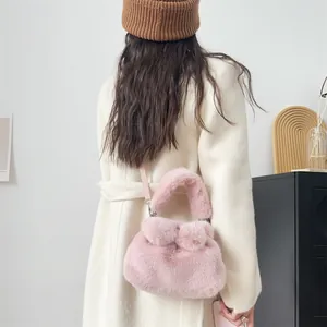 Detailansicht einer rosa flauschigen Handtasche in Schleifenform an einer weißen Jacke