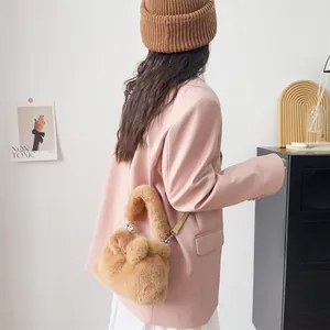 Detailansicht einer plüschigen braunen Schleifen-Handtasche aus weichem Webpelz