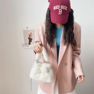 Detailansicht einer weißen Kunstpelzhandtasche mit weicher Schleife und Metallteilen