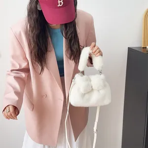Detailansicht einer weißen Plüschhandtasche mit Schleife und Nerzimitat