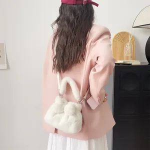 Detailansicht einer weißen, flauschigen Umhängetasche in Schleifenform zu einem rosa Blazer