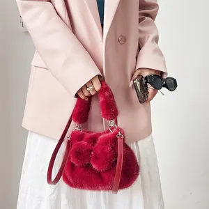 Stilvolle rote Kunstpelz-Handtasche mit Schleife, kombiniert mit einem rosa Blazer-Outfit.