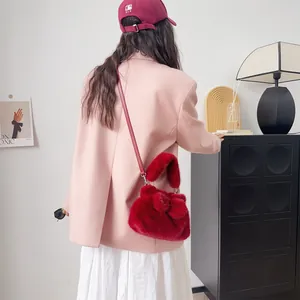Modische rote Plüschtasche aus Nerzimitat mit Schleife an einem Model gezeigt