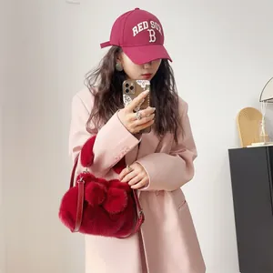 Detailansicht einer hochwertigen roten Kunstpelz-Handtasche mit dekorativer Schleife