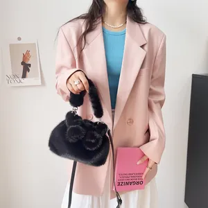 Detailansicht einer schwarzen Handtasche aus Nerzimitat mit flauschigen Schleifen