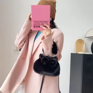 Nahaufnahme einer weichen schwarzen Kunstpelz-Handtasche mit schicker Schleife