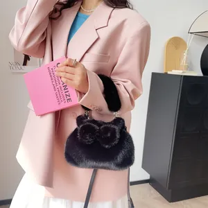 Detaillierte Ansicht der schwarzen Kunstpelz-Handtasche mit Schleife bei einem Model