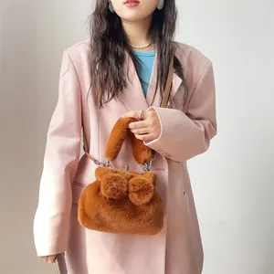 Detailaufnahme einer braunen flauschigen Kunstpelz-Handtasche mit stilvollem Schleifendesign.