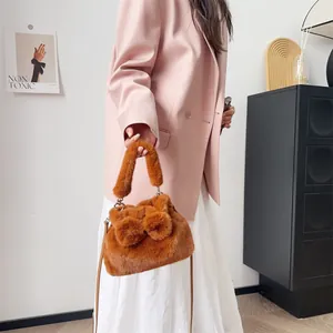 Braune Plüschhandtasche mit Schleifendetails und Lederriemen im Lifestyle-Ambiente