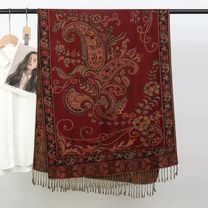 Vue détaillée d'une écharpe pashmina rouge à motifs paisley jacquard et longues franges.