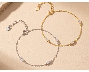 Primo piano di eleganti pietre marquise e ciondoli a cuore su bracciali oro e argento